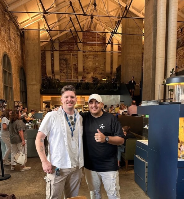 Paul with an operator inside a busy warehouse restaurant
