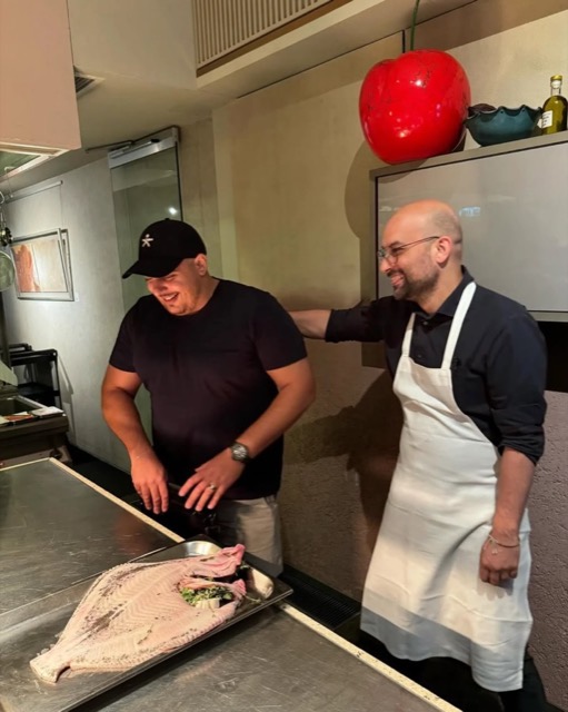 Paul in the kitchen with a chef and a salt-baked fish